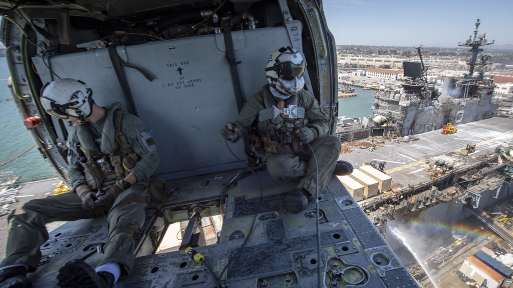 Sailor utilize a Bambi bucket in an MH-60S Seahawk helicopter to provide aerial firefighting.