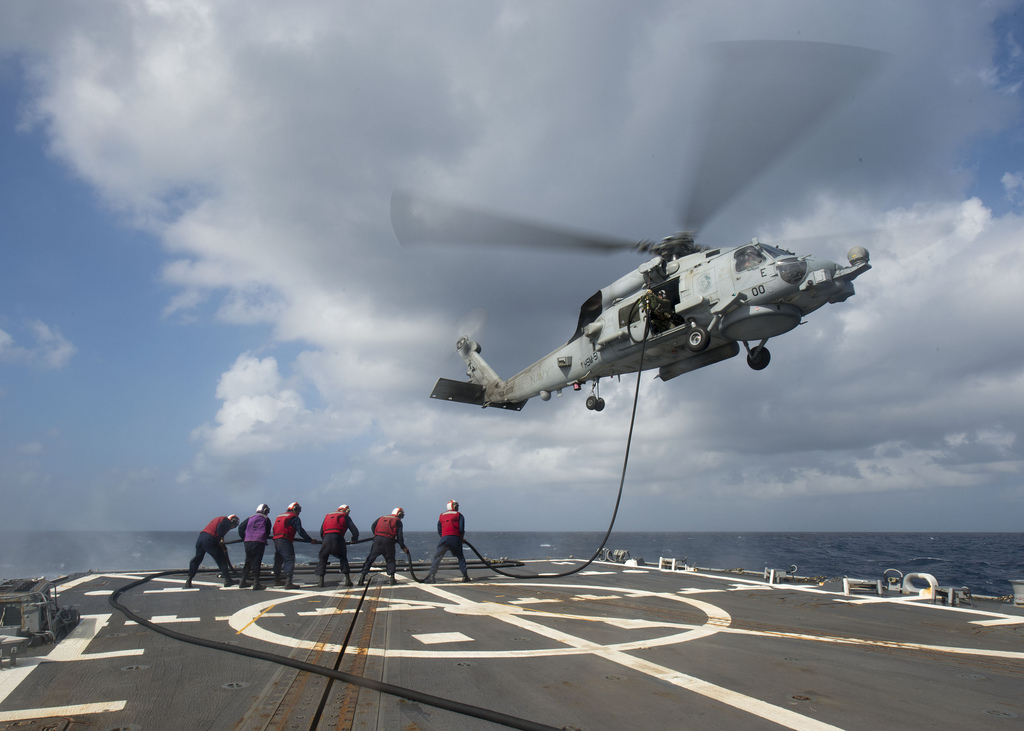 Sailors refuel a a MH-60R Seahawk helicopter